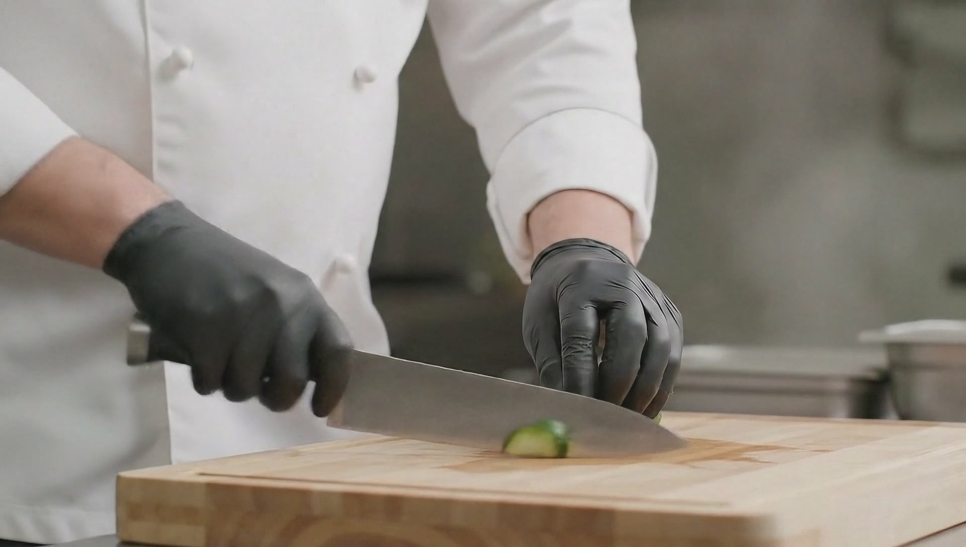 Load video: Food service worker wearing blue nitrile gloves while preparing ingredients in a commercial kitchen, demonstrating hygiene and safety in food handling.
