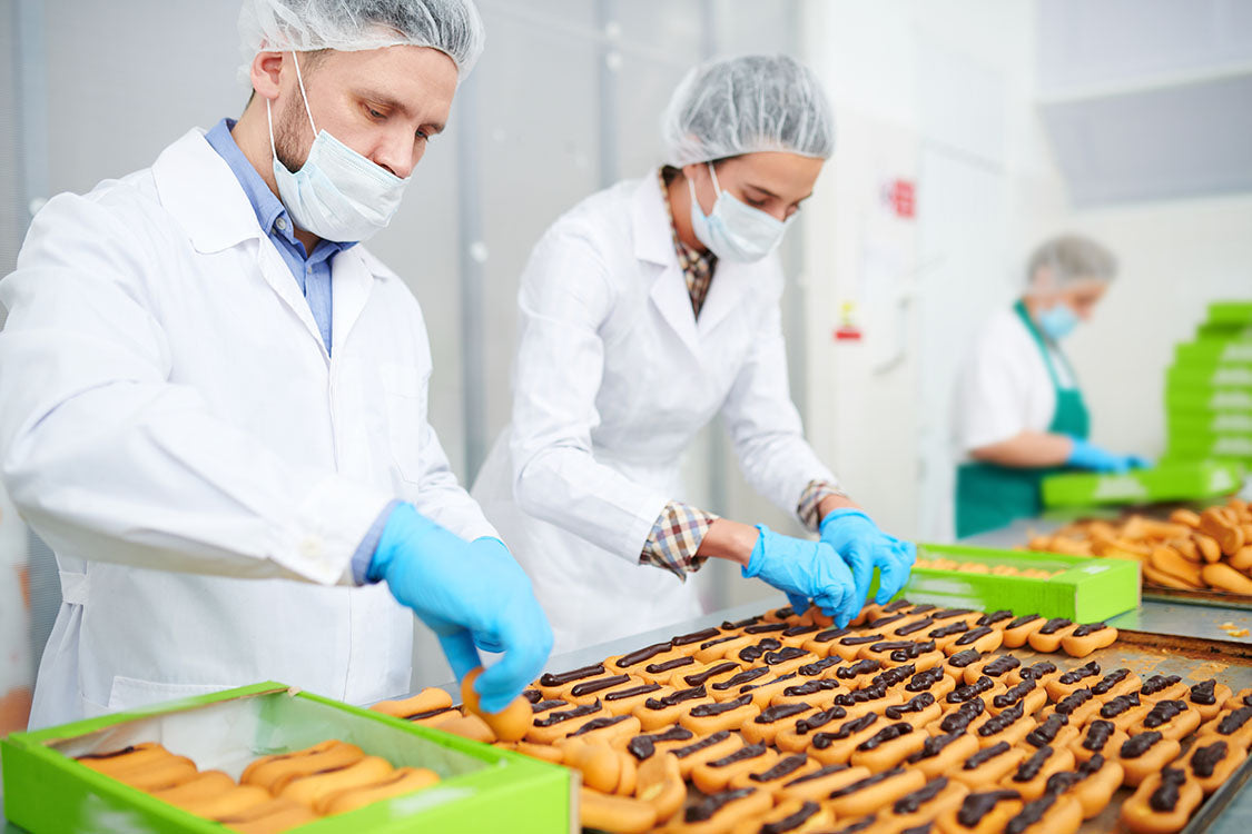 Blue gloves and hairnets used by workers in food processing